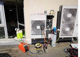 Technician repairing an outdoor heat pump condenser unit