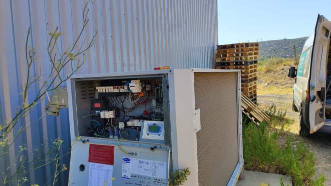 A professional HVAC technician servicing a wall-mounted split air conditioning indoor unit in a modern French home